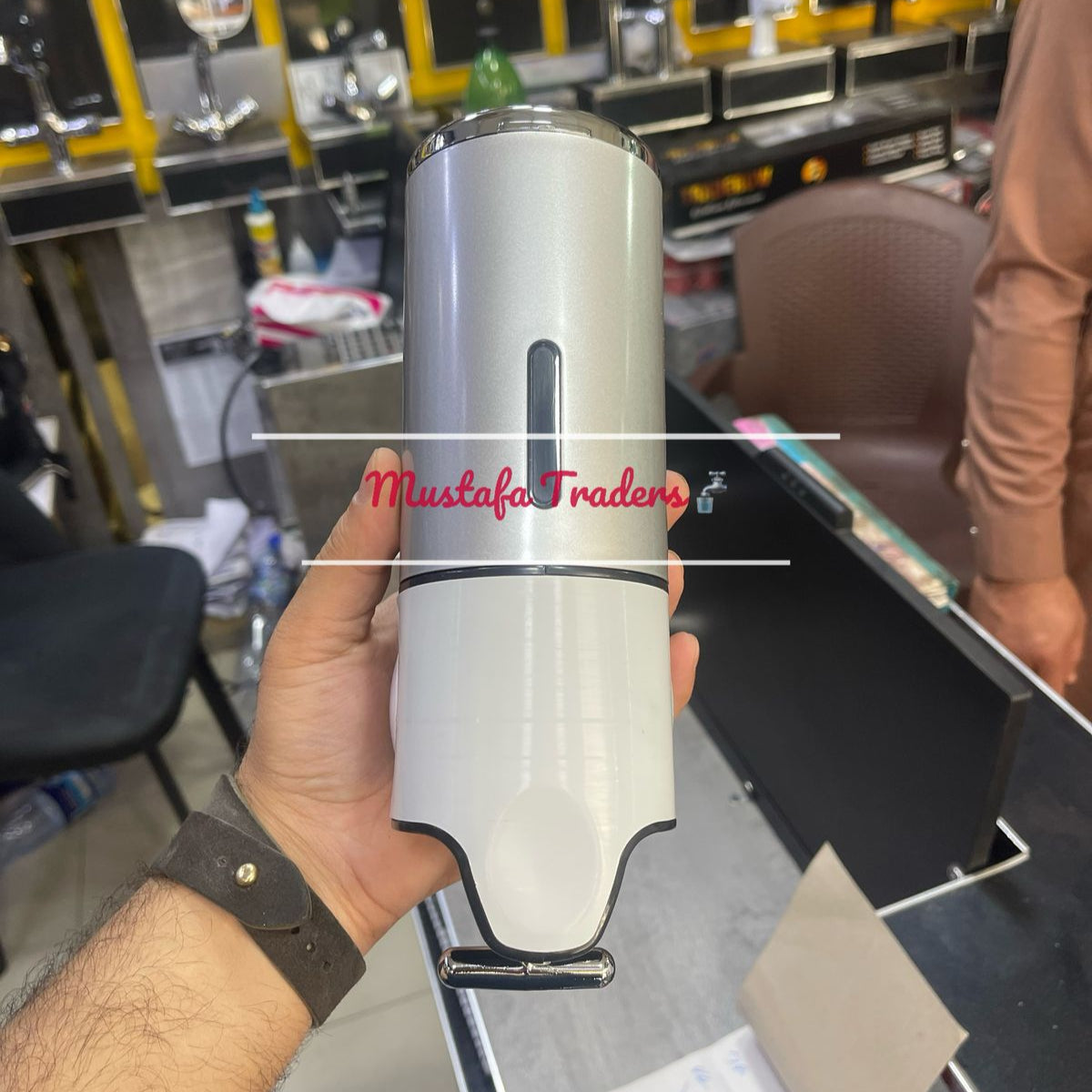hand holding soap dispenser in shop
